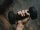 Person holding a dumbbell amid calls by IT professionals for stronger AI regulation, according to SolarWinds research.